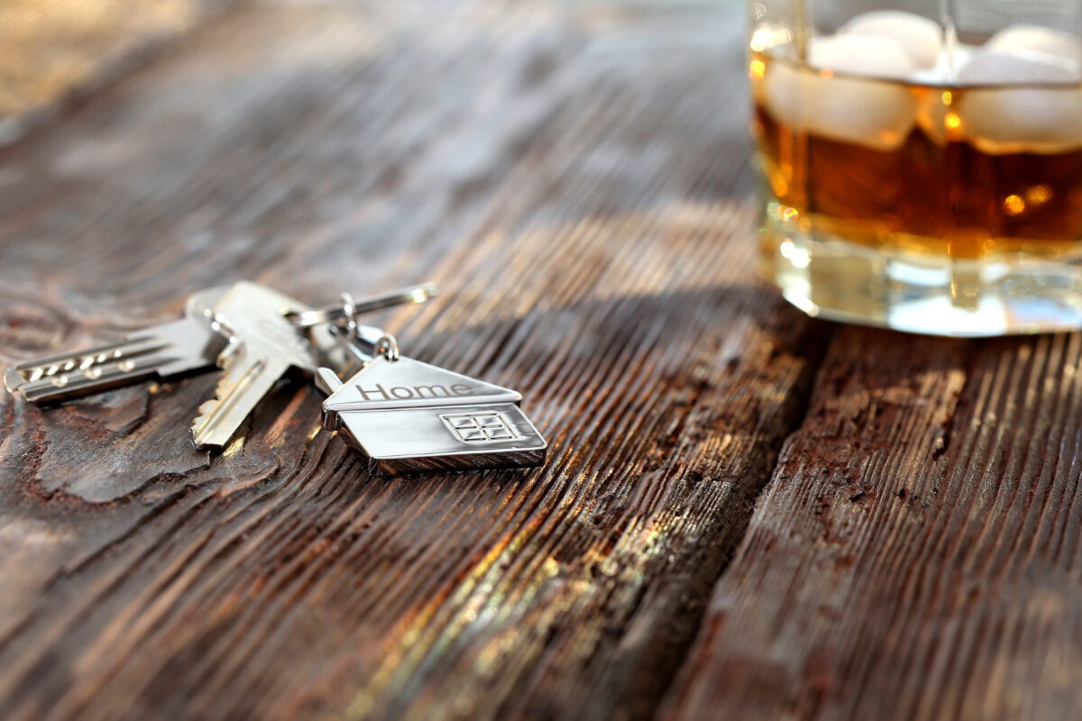 keys next to glass of liquor