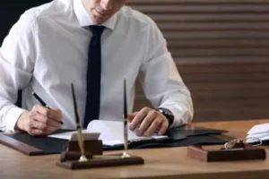 A DUI defense attorney takes notes at his desk.