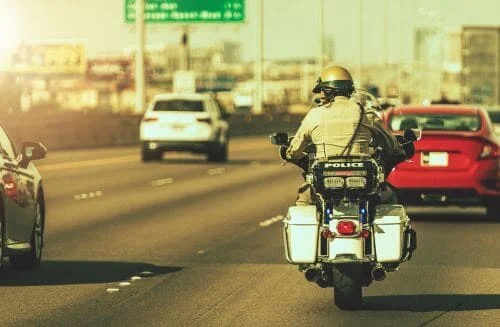 A Florida Highway Patrol officer drives down a Florida highway on a motorcycle.