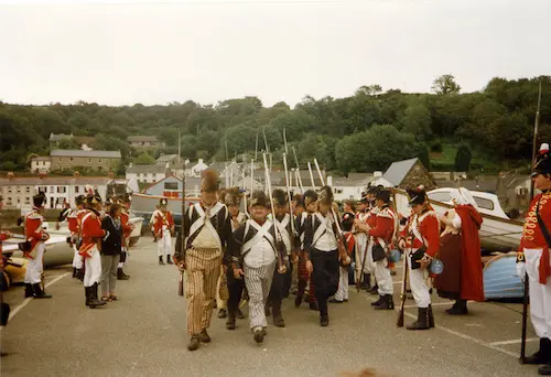 During an American Revolution reenactment, soldiers march down the street