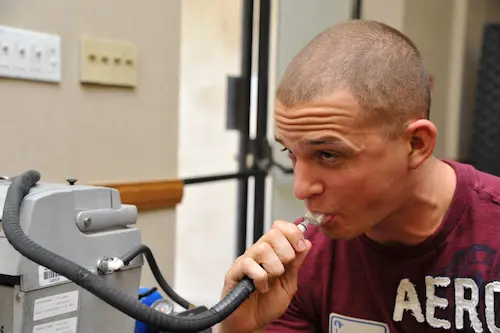 Male taking a breathalyzer during a training session