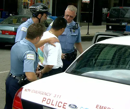 Man being arrested by 3 policemen